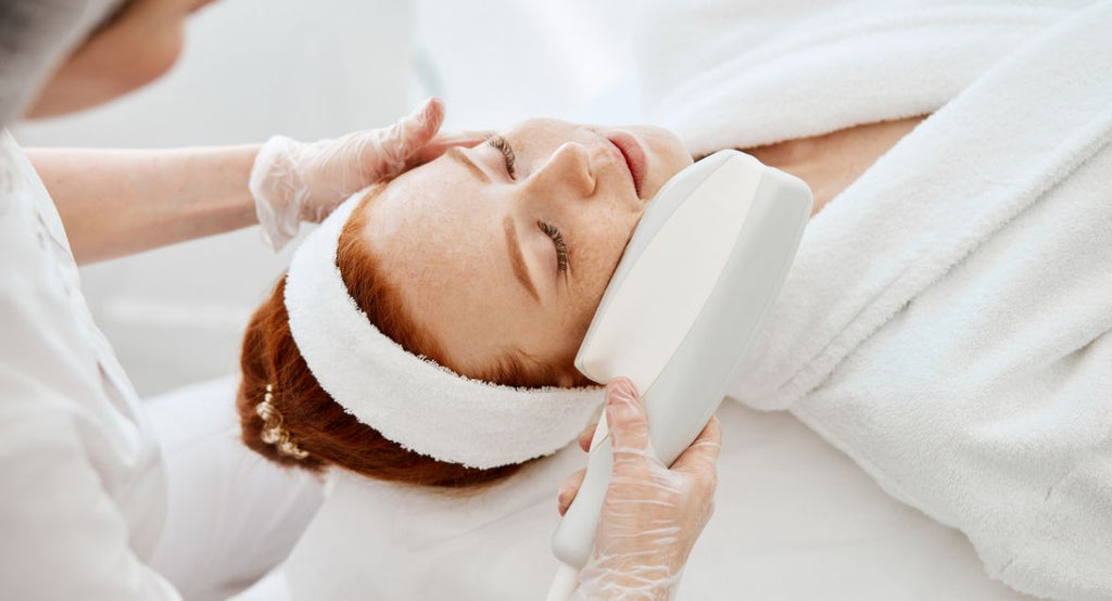 redhead woman receiving HIFU skin rejuvenation treatment on side of face