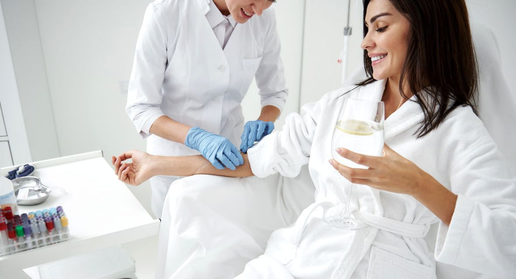 woman in white gown receiving IV drip therapy