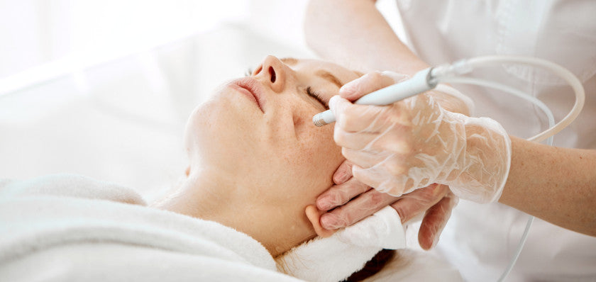 aesthetic doctor applying chemical peel solution to face of female patient